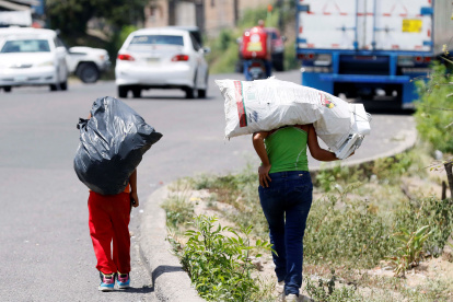 Dos niños cargan bolsas donde llevan botes plásticos para reciclar en Olancho (Honduras), en una fotografía de archivo.