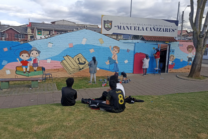 Cuenca. El trío de mujeres trabaja en el mural de una escuela local.