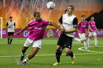 El delantero de Porcinos FC Ronaldo de Assis Moreira "Ronaldinho" (i) lucha con Lopo, de PIO FC, durante el partido de la Kings League