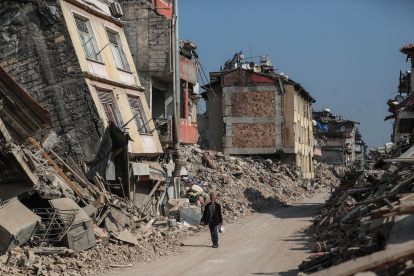 Un hombre pasa junto a edificios derrumbados tras los fuertes terremotos en Hatay, Turquía, el 23 de febrero de 2023.