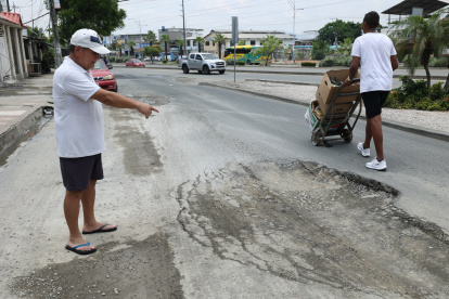 Pedro Ruiz, quien reside en la manzana 3021 de Las Orquídeas, muestra el hundimiento que ha sufrido la calzada cerca de su vivienda, lo que representa un peligro para los peatones.