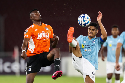 Kevin Minda (d) de Católica disputa un balón con Jader Valencia de Millonarios.