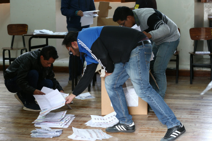 Vocales de una mesa de votación realizando el proceso de conteo de votos, tras el cierre del sufragio.