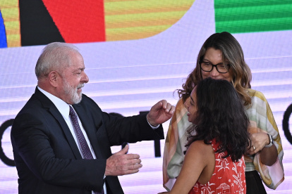 El presidente de Brasil, Luiz Inácio Lula da Silva, junto a su esposa, Janja da Silva, saluda a la ex beneficiaria de Bolsa Familia, Isamara Mendes da Silva, durante el nuevo lanzamiento de ese programa brasileño de combate el hambre, hoy, en el Palacio del Planalto en Brasilia (Brasil). Lula da Silva relanzó este jueves un programa de subsidios que en sus primeros dos mandatos (2003-2010) redujo las tasas de pobreza y que ahora pretende rescatar del hambre a unas 33 millones de personas. El nuevo Bolsa Familia estará dotado con unos 175.000 millones de reales (33.650 millones de dólares), cifra equivalente a cerca del 1,5 % del Producto Interno Bruto (PIB), y se calcula que atenderá a unas 60 millones de personas (poco más del 30 % de la población). EFE/ Andre Borges