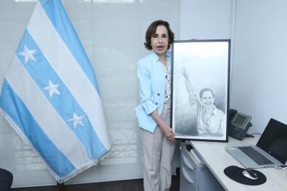 La exfuncionaria posa con un retrato en su oficina