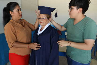 Josefina Chagua, junto a su maestra Kenia Pazos y su nieto Brayan Erazo, en los ensayos de la ceremonia de graduación que será el 22 de marzo.
