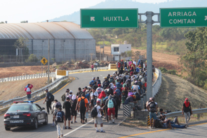 Migrantes caminan en caravana en una carretera de México.