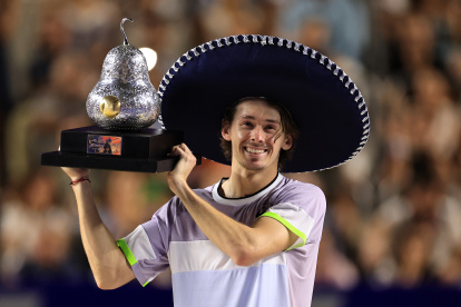 El tenista australiano Alex De Minaur, celebra con el trofeo de campeón al derrotar al estadounidense Tommy Paul.