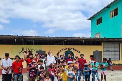 El padre Simón Mahish aparece en medio de un grupo de niños de la la unidad educativa El profeta Jeremías