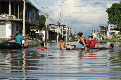 En flotadores o balsas, los habitantes de Milagro se movilizan por las lluvias.