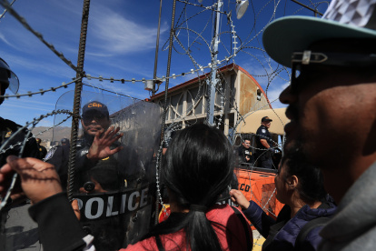 Policías estadounidenses acuden a controlar una protesta de cientos de migrantes.