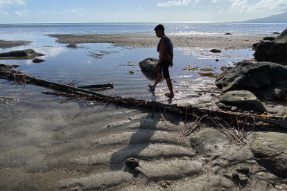 Un hombre camina sobre un puente en una zona afectada por la contaminación tra el derrame de aceite industrial