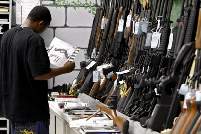 Fotografía de archivo en la que se registró a un hombre al detallar el manual de un pistola, dentro de una tienda de armas, en Kansas (EE.UU.). EFE/Larry W. Smith