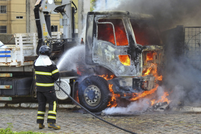 Un bombero intenta controlar el fuego de un camión en llamas, hoy, en Parnamirim, en el estado Río Grande del Norte (Brasil).