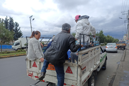 Camionetas cobran medio dólar para transportar a personas a ciudadanos en las veredas de la ciudad de Ambato.
