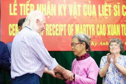 El veterano de guerra estadounidense Peter Mathews entrega el diario del fallecido soldado vietnamita Cao Van Tuat a su hermana.