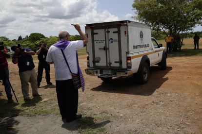 El monseñor José Luis Lacunza bendice los vehículos donde se encuentran los cuerpos de migrantes fallecidos durante un accidente en autobús el pasado mes de febrero, hoy en David (Panamá).