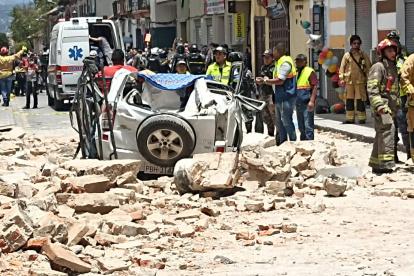 Víctimas. En Azuay, Cuenca, Bomberos socorren a un ciudadano que quedó atrapado en el vehículo tras caída de una pared.