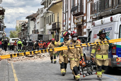 Miembros de los bomberos ayudan con los daños ocasionados por el sismo de magnitud 6,5 en la escala abierta de Richter hoy, en la ciudad de Cuenca (Ecuador).