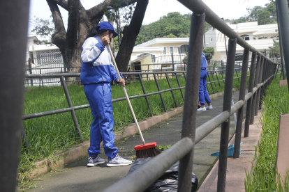 Tres policías de la UPC del sector Los Ceibos colaboraron en la limpieza del parque.