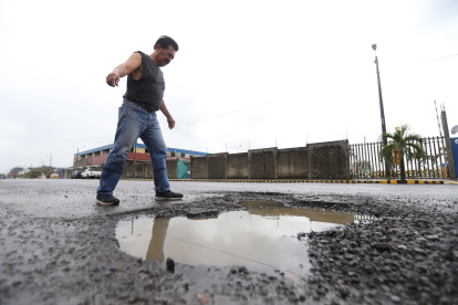 Reclamos. Un ciudadano se queja por los enormes baches que se observan en Mucho Lote 2, en Guayaquil. Los peatones también quieren demandar por los perjuicios provocados.