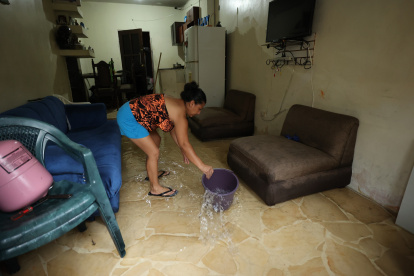 Inundación. Una ama de casa saca el agua que se metió a su casa por la lluvia y aguaje que hubo en Guayaquil, sus enseres se afectaron.