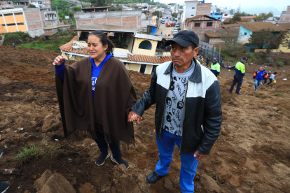 Pobladores observan los daños causados por un deslizamiento de tierra hoy, en Alausí (Ecuador). Un gran deslizamiento de tierra sepultó la noche de este domingo un barrio de la ciudad de Alausí, en la provincia de Chimborazo, en el centro andino de Ecuador, donde aún se mantiene una operación de rescate de víctimas.