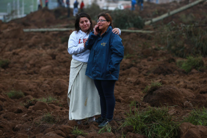 Familiares se lamentan hoy en la zona donde se presentó un deslizamiento de tierra, en Alausí (Ecuador).