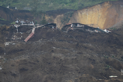 Familiares se lamentan hoy en la zona donde se presentó un deslizamiento de tierra, en Alausí (Ecuador).