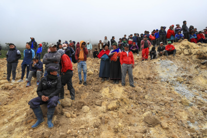 Familiares de desaparecidos observan como rescatistas buscan a victimas tras un alud, hoy en Alausí (Ecuador).