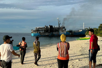 Un grupo de personas observa el incendio en el ferri de pasajeros en Basilan. EFE/EPA/HMM / HANDOUT HANDOUT EDITORIAL USE ONLY/NO SALES
