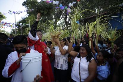 Un sacerdote bendice a los feligreses durante la celebración del Domingo de Ramos.