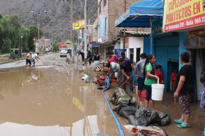 Residentes intentan sacar el agua de sus casas y locales inundados por el ciclón Yaku, en el distrito de Chaclacayo, en Lima.