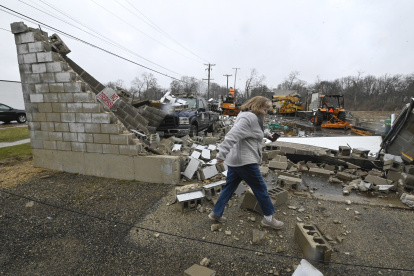 Una mujer pasa frente a un negocio destruido tras un tornado en Belvidere, Illinois, EE.UU.