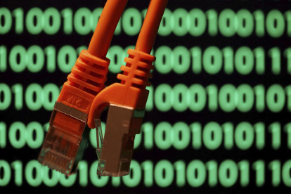 Imagen de archivo de unos cables sobre una pantalla de ordenador con un código binario en Colonia, Alemania. EFE/Oliver Berg