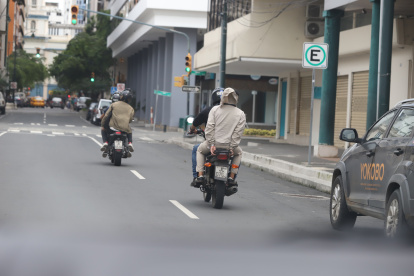 Dos personas en moto y sin casco siguen circulando por calles y avenidas de Guayaquil.