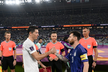 Lewandowski (i) y Messi estrechan saludo durante la Copa del Mundo de Qatar 2022.
