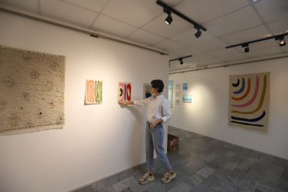 Arte. Mikaela Báez, curadora y una de los artistas participantes en la muestra, acomoda una de las obras.