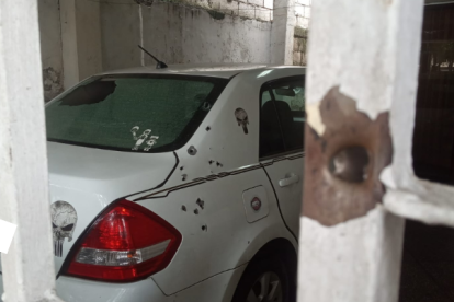 Las rejas de la puerta y la parte trasera de un vehículo quedaron con orificios de proyectiles.