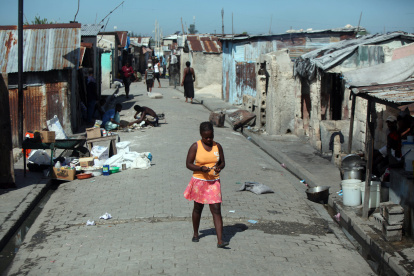 Imagen de archivo de una mujer camina por una calle en el barrio Cité Soleil de Puerto Príncipe (Haití).