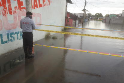 Personal del Cuerpo de Bomberos señaliza algunas zonas inundadas para evitar el paso de las personas y posibles accidentes
