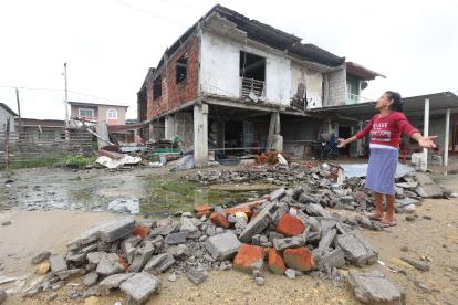 Una mujer contempla y reclama por el estado de su casa después de un mes