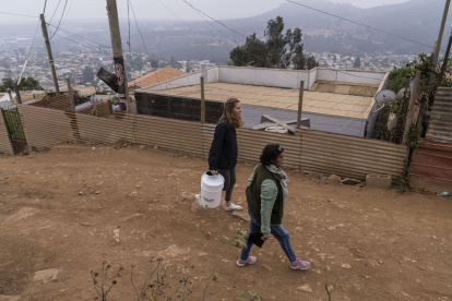 Recorrido. Emilia Venegas (d), dirigente comunitaria, y María Paz Valdivia, de la ONG, caminan por una calle local.