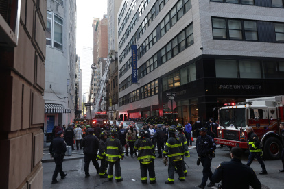 Equipos de bomberos fueron registrados este martes, 18 de abril, al atender la emergencia por el desplome de un aparcamiento de vehículos de cuatro pisos, en el Distrito Financiero neoyorquino, en el Bajo Manhattan, en Nueva York (NY, EE.UU.). EFE/Justin Lane