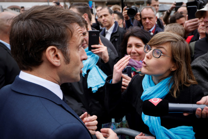 Selestat (France), 19/04/2023.-Emmanuel Macron (L), habla con una persona que se opone a la reforma de las pensiones, en Selestat, este de Francia, el 19 de abril de 2023.