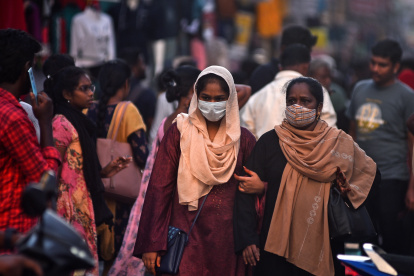 Dos mujeres con mascarilla pasan por una calle llena de gente en Chennai, India, el 11 de abril de 2023. EFE/EPA/IDREES MOHAMMED