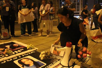Reacción. El pasado el 4 de abril, una mujer coloca fotos y panfletos con nombres de las víctimas de femicidio  frente al Palacio de Justicia en Lima.