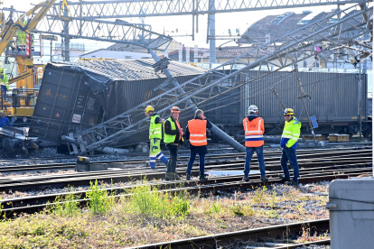Trabajadores junto al tren de mercancías descarrilado cerca de una estación en la ciudad italiana de Florencia.