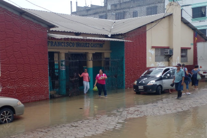 Padres de familia y maestros realizan sus labores en un plantel inundado en Salitre.