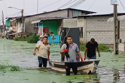 En Santa Lucía, un grupo traslada en una canoa los electrodomésticos desde un sector anegado.